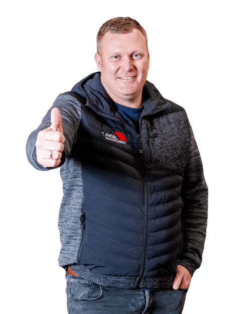 Lächelnder Mann in dunkler Steppjacke mit T. Knöbl-Logo zeigt den Daumen hoch